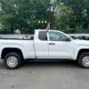 Side view of a white pickup truck with a flag at Garden State Auto Boutique.
